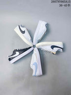 Overhead arrangement showing several Nike low-top sneakers in white, dark and light blue color combinations.