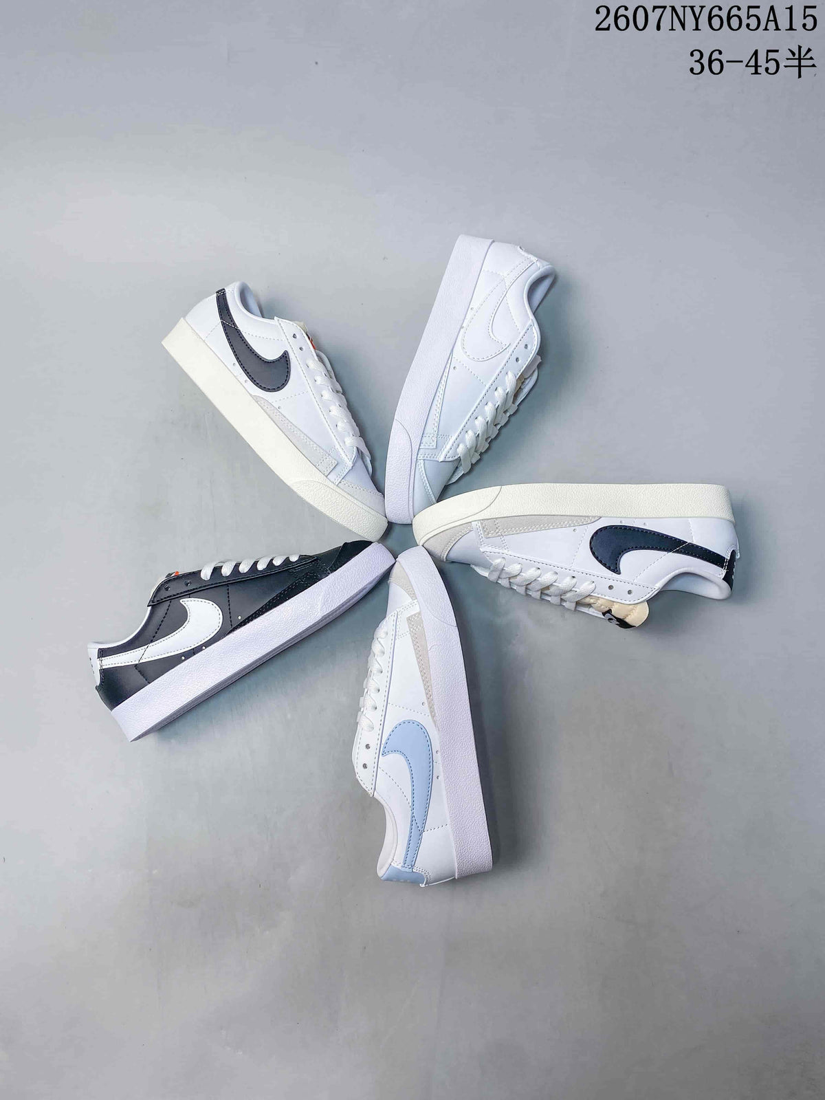Overhead arrangement showing several Nike low-top sneakers in white, dark and light blue color combinations.