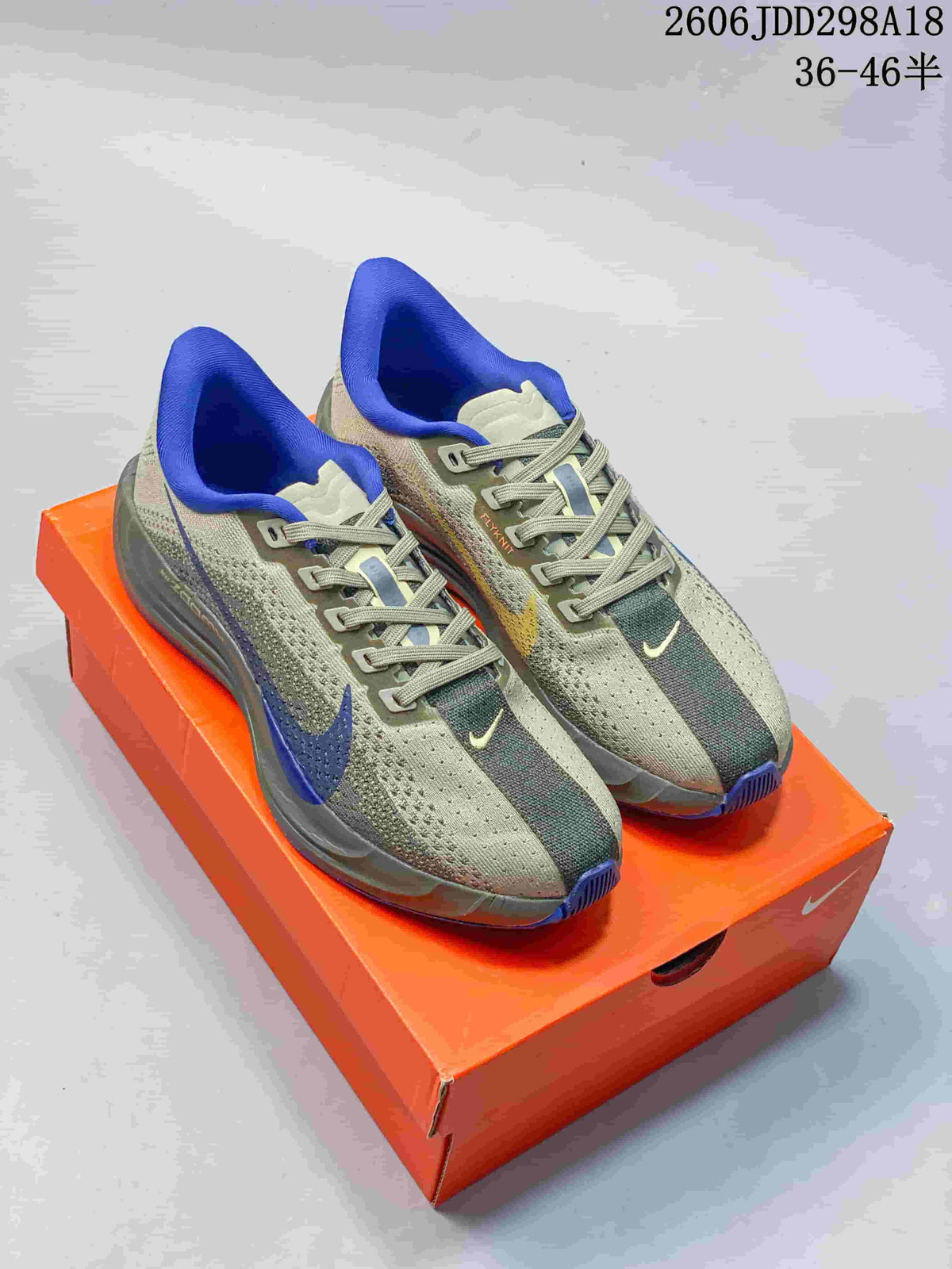 Gray Nike Pegasus Plus Next Nature shoes with blue accents on an orange shoebox