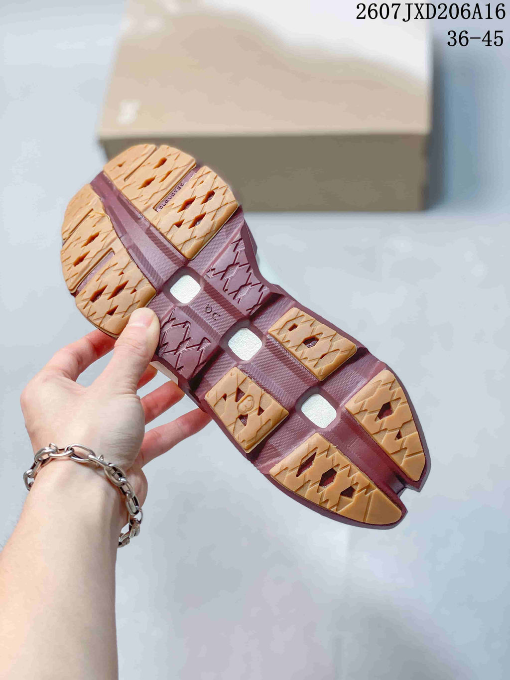 Underside view showing the segmented burgundy and gum-colored outsole pattern.