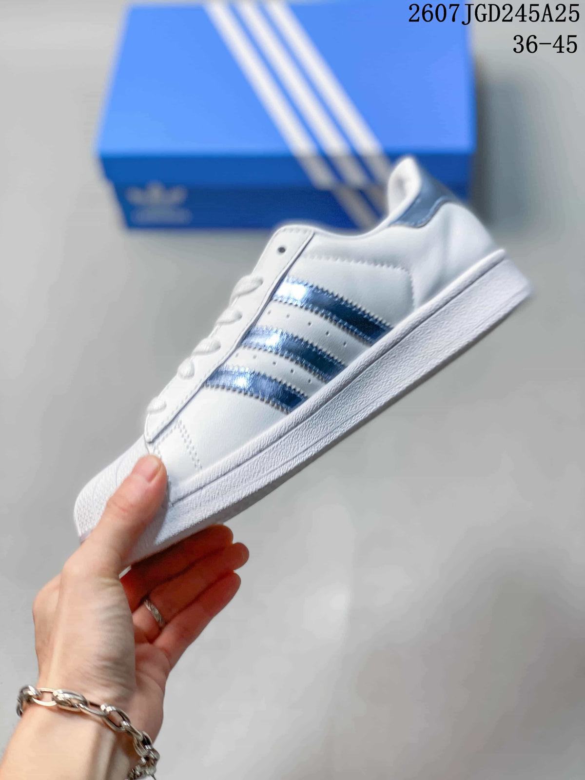 Side view highlighting the white upper, three blue stripes, and low-top silhouette.