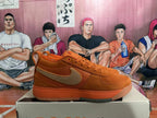 Side view of an orange Nike low-top sneaker with a tan Swoosh