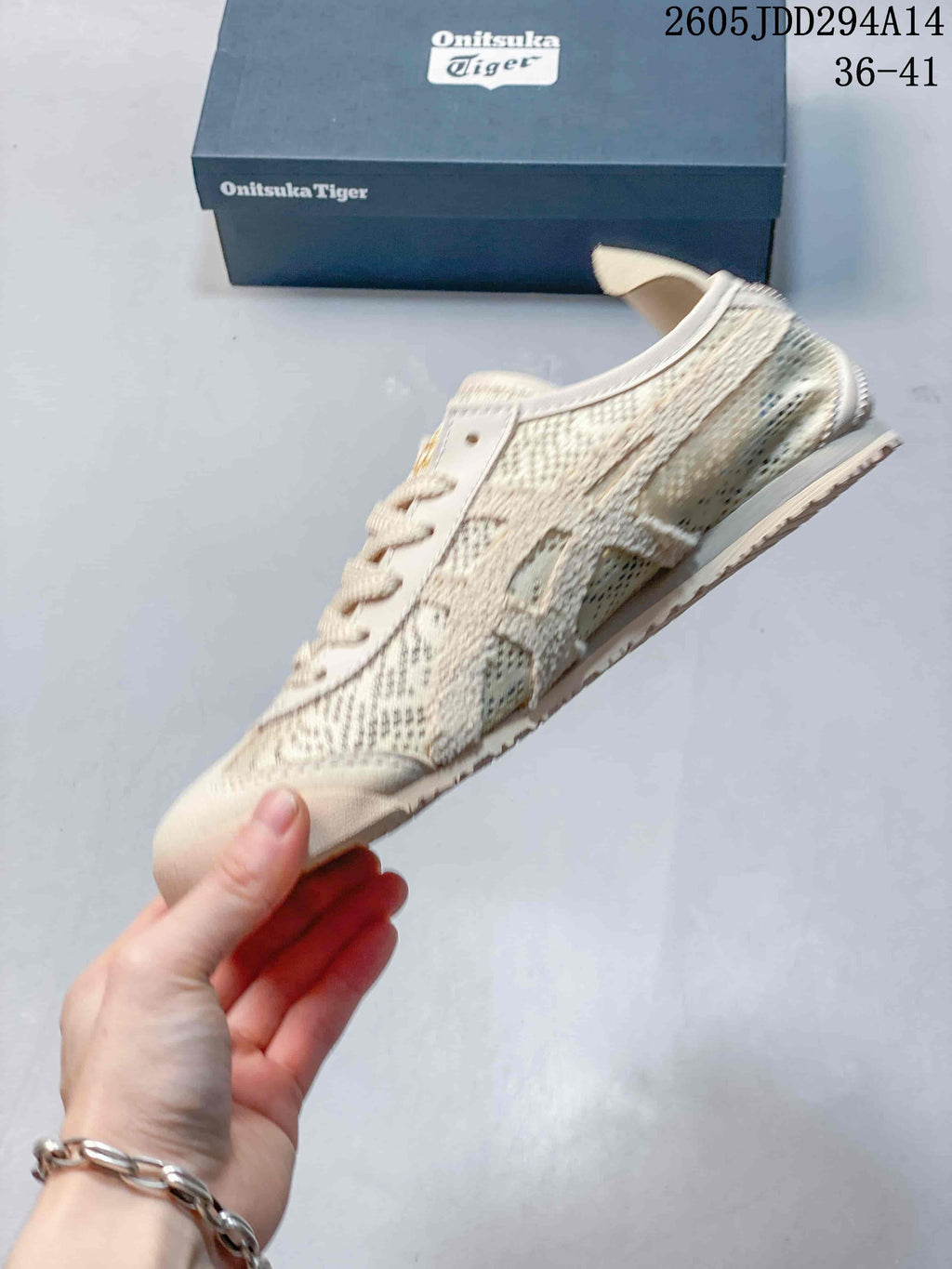Side view of the Onitsuka Tiger sneaker showing the low-top shape, textile panels, side detailing, and flat sole.