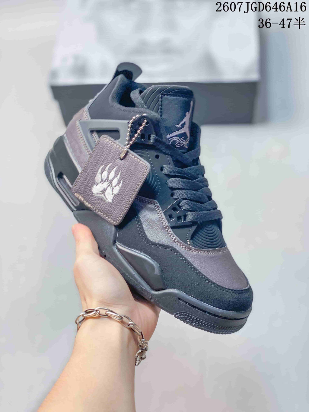 Angled front-side view showing the charcoal and black upper, lace system, side panel, and hangtag.