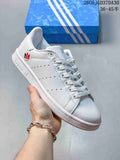 White Stan Smith-style sneaker with a multicolor heel emblem and a blue heel tab.