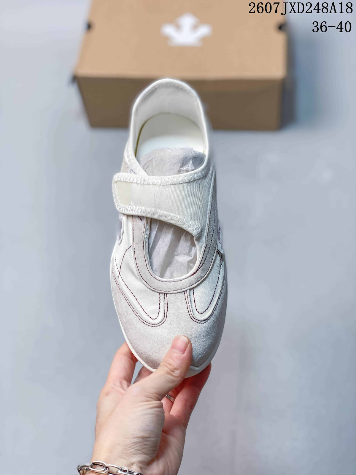 Top view of the white sneaker showing the front strap and layered toe-panel design; the image shows the code 2607JXD248A18 and size range 36–40.