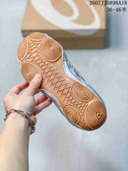 View of the gum-colored outsole showing circular traction patterns and geometric tread details.