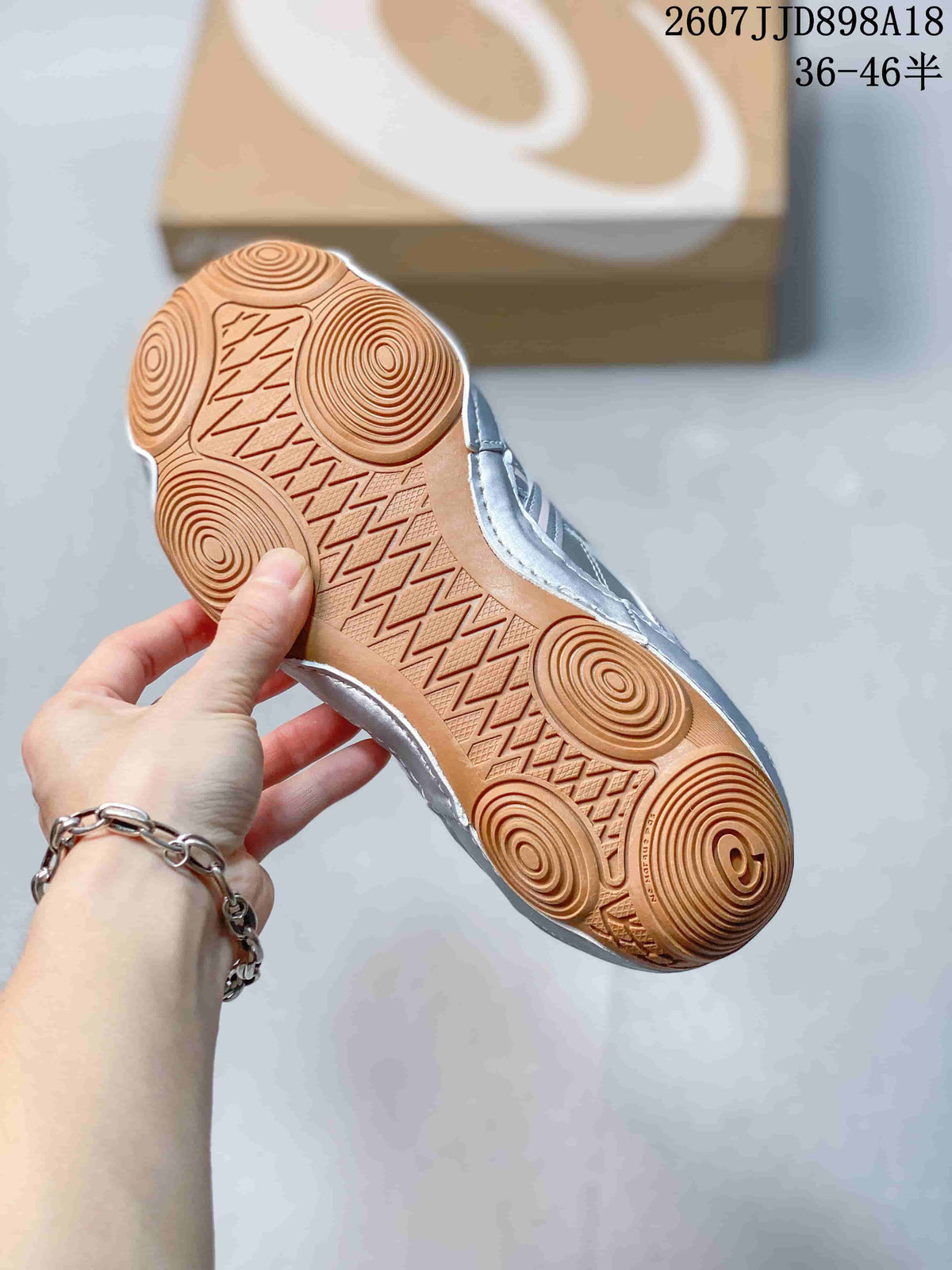 View of the gum-colored outsole showing circular traction patterns and geometric tread details.