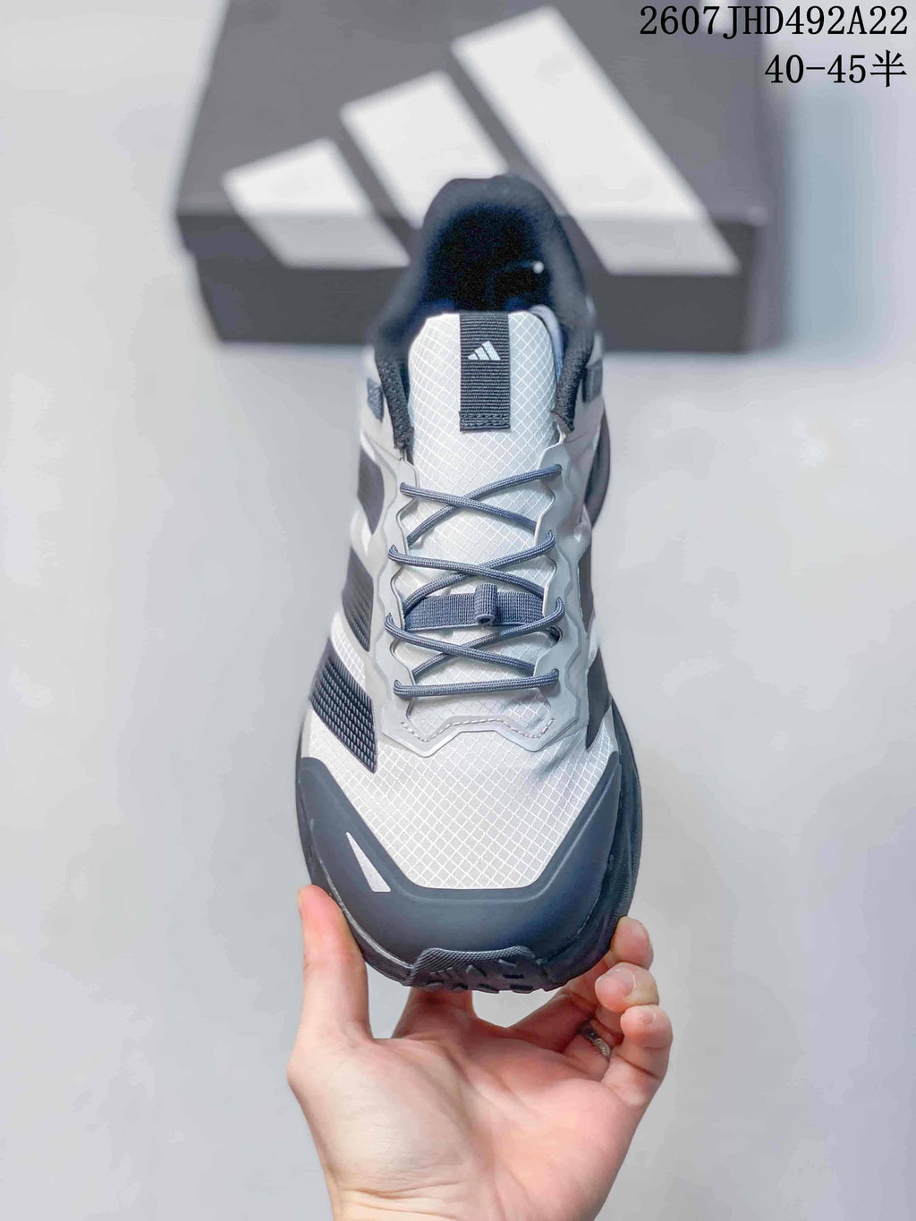 Top view showing the white patterned toe and tongue, gray laces and black padded collar.