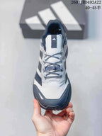 Top view showing the white patterned toe and tongue, gray laces and black padded collar.