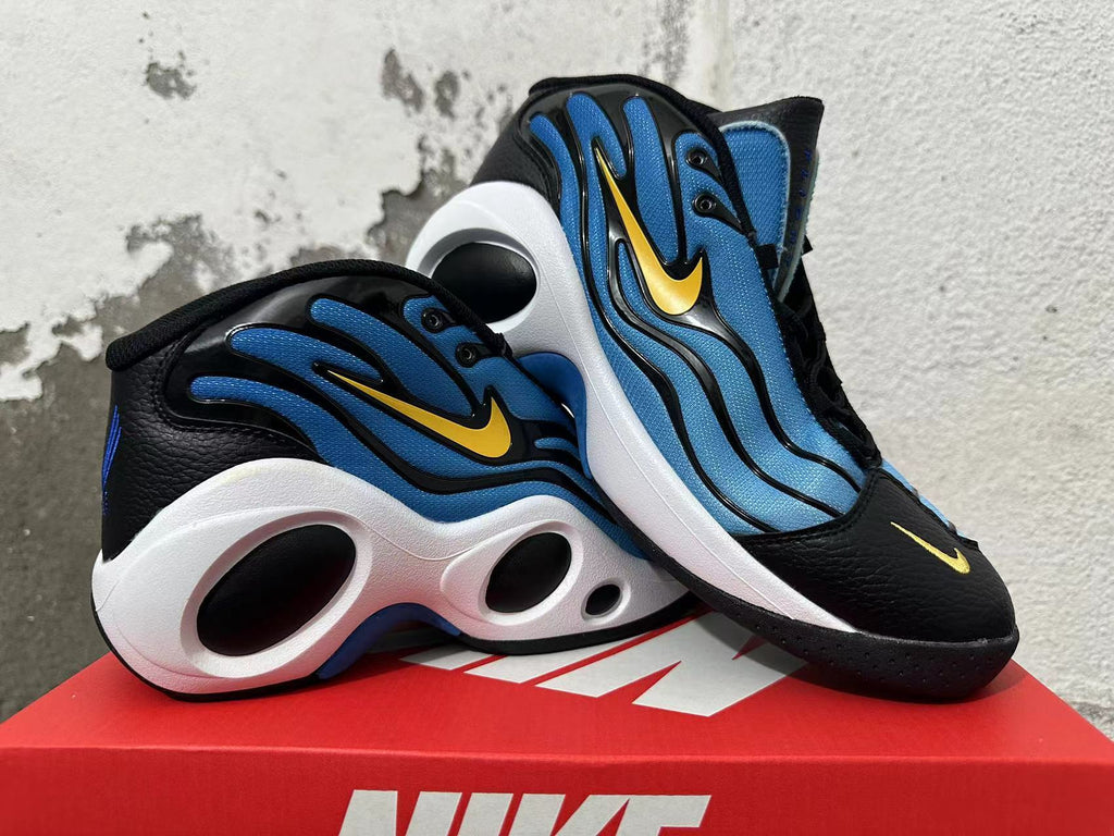 Pair of blue, black, and white Nike sneakers shown at an angle with yellow Swoosh accents.