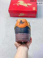 Rear view showing orange collar panels, dark navy heel, and burgundy-colored sole