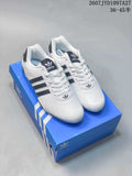 Pair of white and black Adidas Superstar sneakers displayed on a blue shoebox.