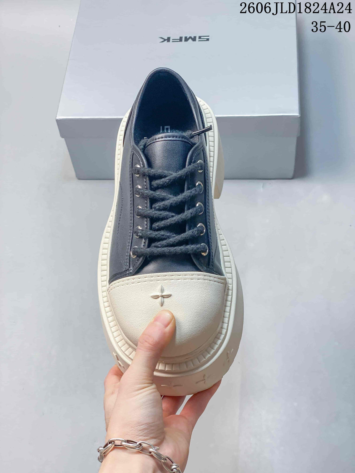 Top view of the sneaker showing dark laces, metal-tone eyelets, and an ivory toe cap