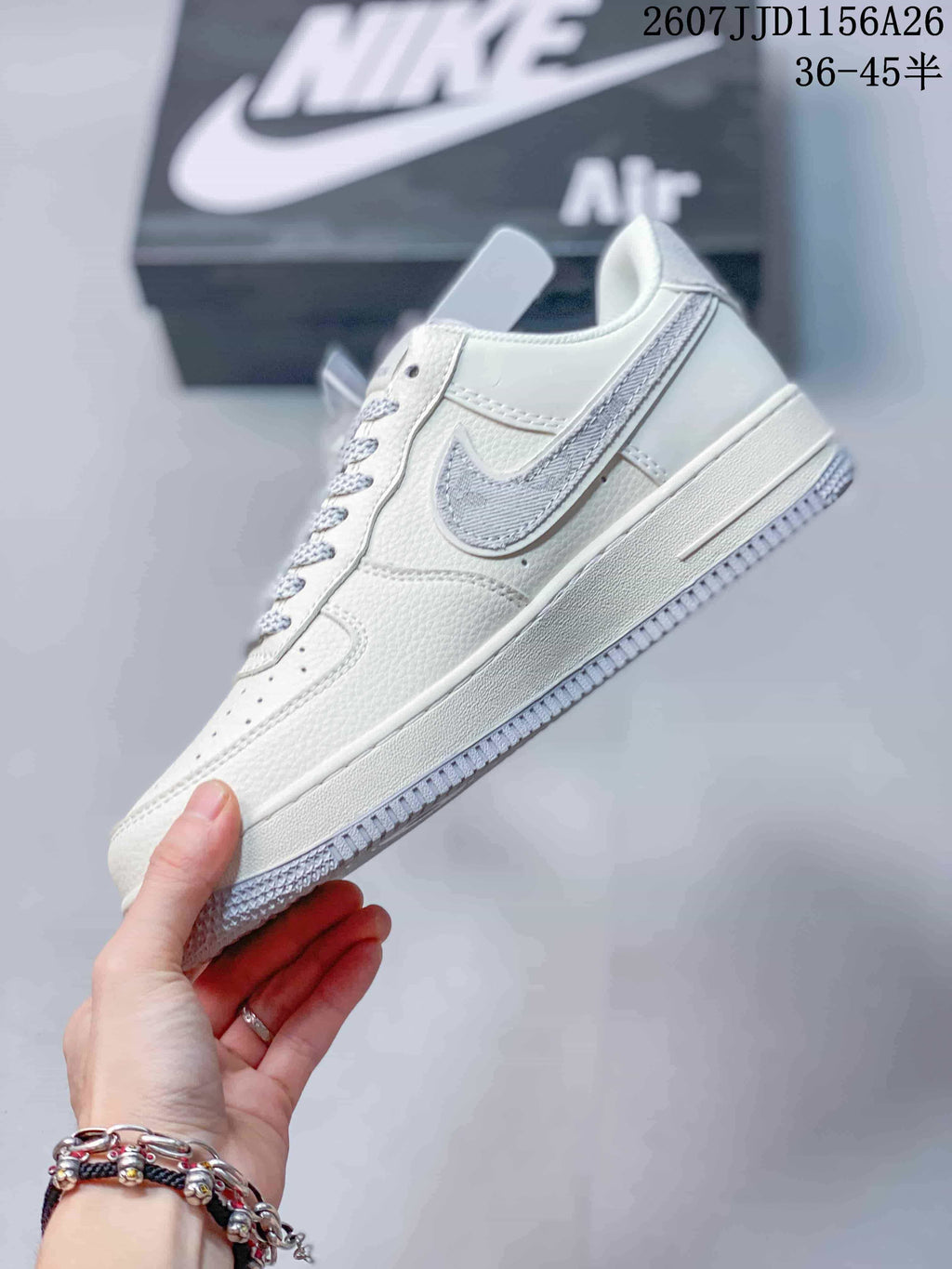 Side profile of the white low-top sneaker with grey side detailing, perforated panels and layered sole.