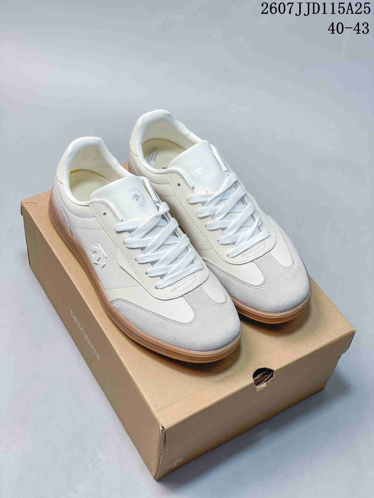 Pair of white and light grey DESCENTE low-top sneakers displayed on a shoebox, with a gum-colored outsole.