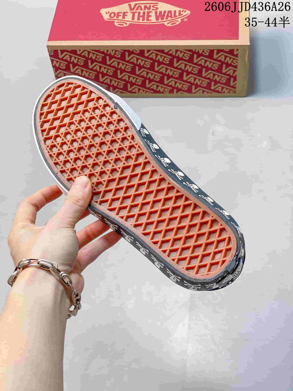 Underside of a sneaker showing the orange waffle-pattern outsole and skull graphics along the sidewall.