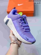 Purple and white training sneaker with layered side straps, a white segmented sole and a black Nike Swoosh.