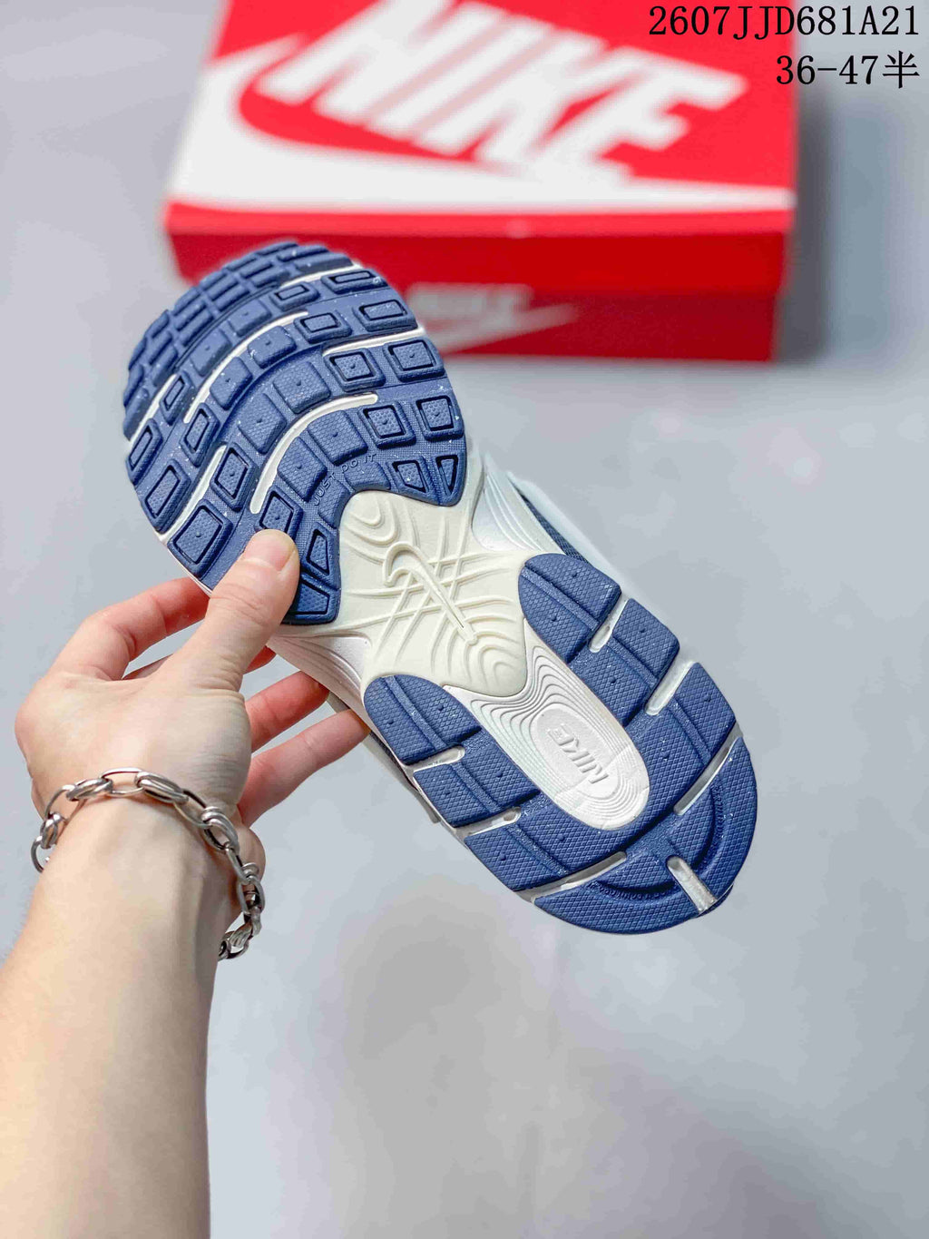 Underside view of a Nike V5 RNR sneaker showing the blue segmented outsole and white central midsole section.