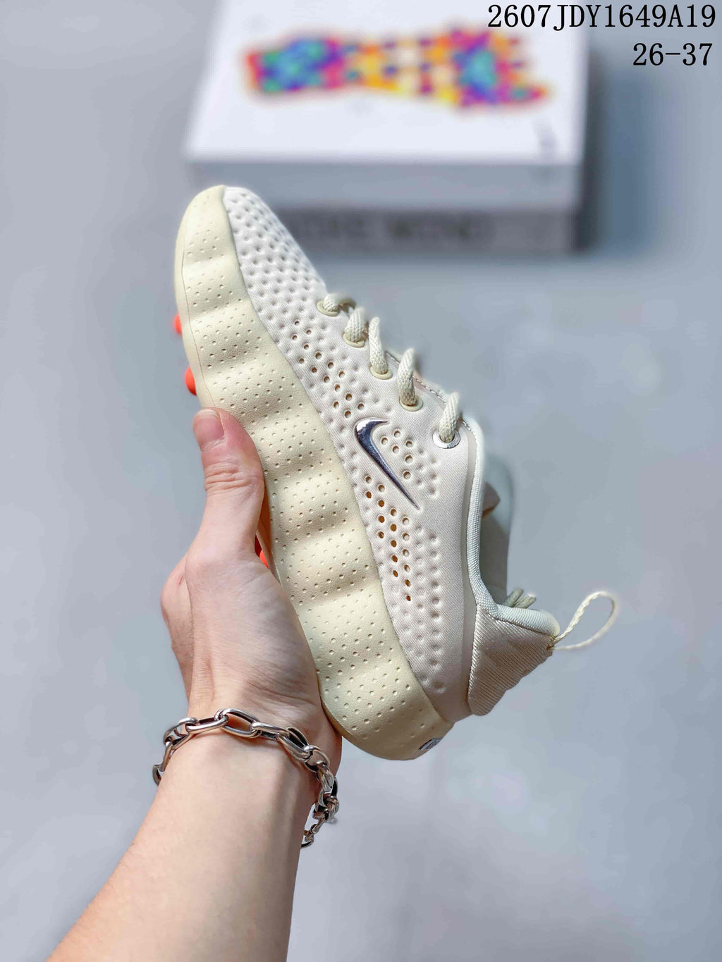 Side profile of the cream sneaker showing the perforated upper, layered midsole, and lace-up construction.