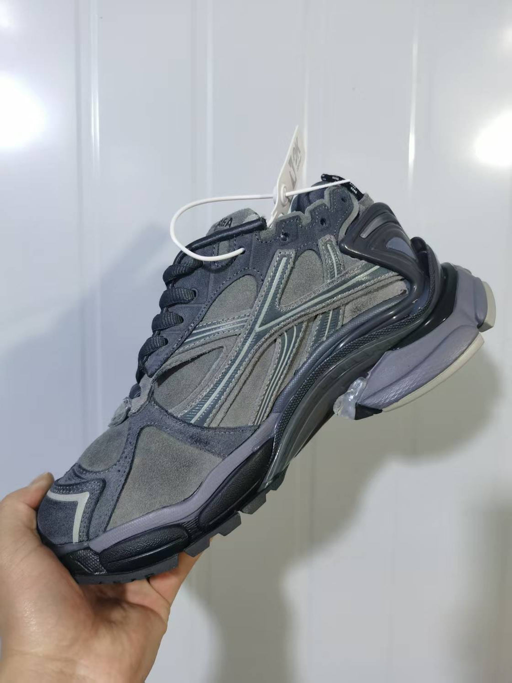 Side view of the grey Puma 1100 sneaker highlighting the layered upper, heel structure and contrasting outsole.