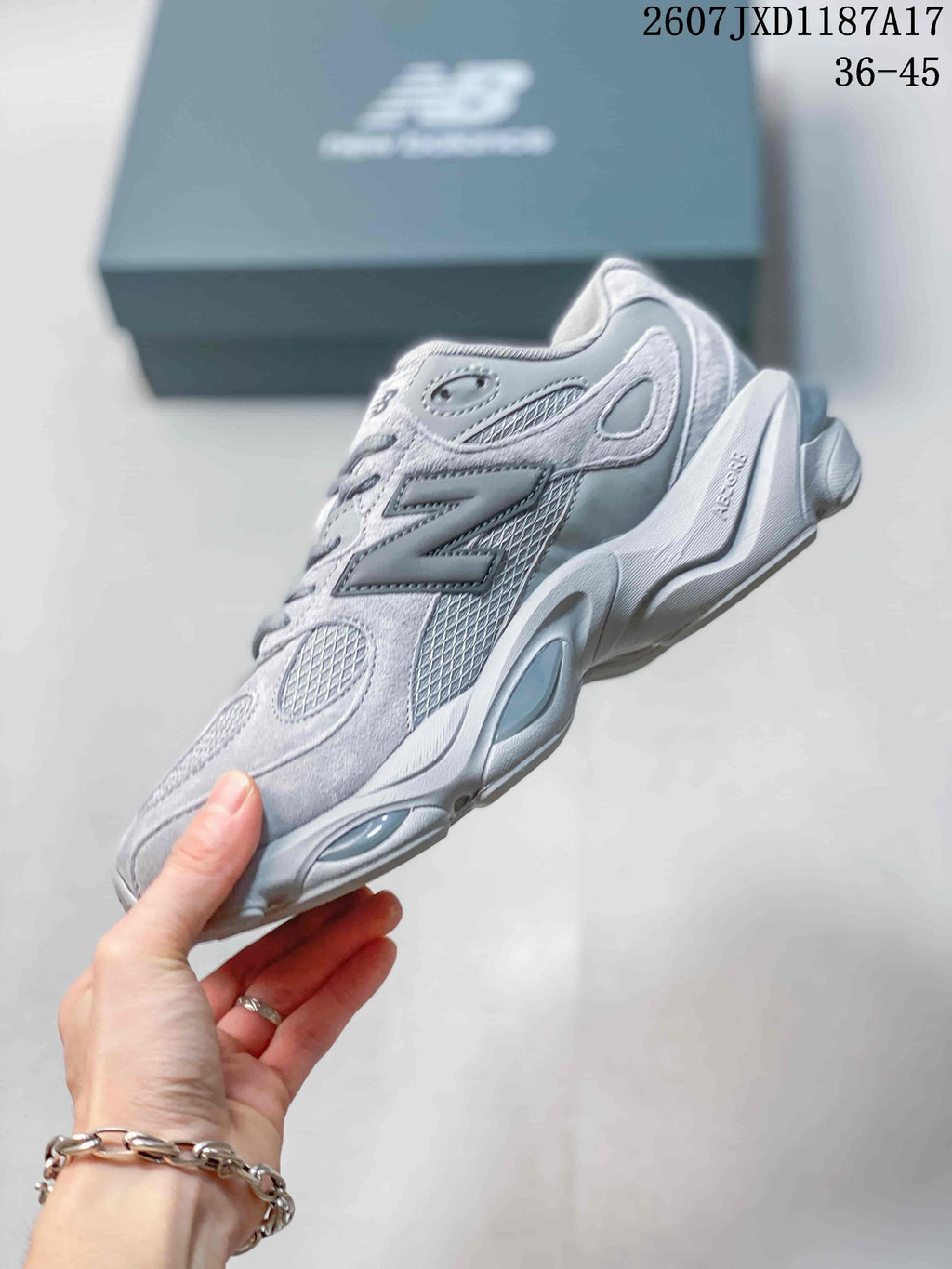 Side view of the grey New Balance sneaker highlighting the layered upper, mesh panels, and sculpted sole.