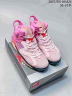 Pair of pink high-top Nike Air Jordan 6 sneakers displayed on a shoebox, showing white laces, red accents and black outsole details.