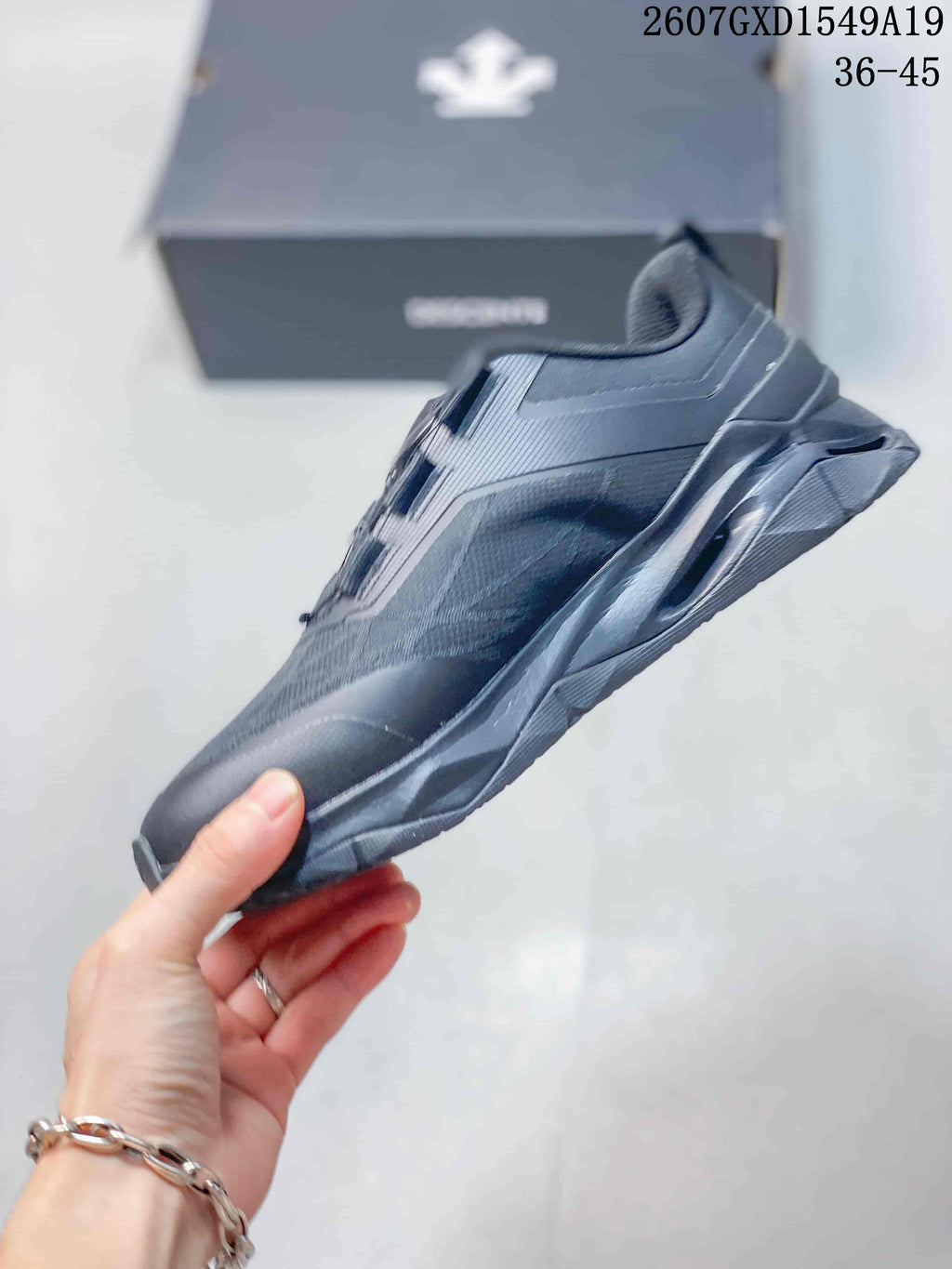 Side view of the black low-top sneaker showing layered panels and the sculpted sole.