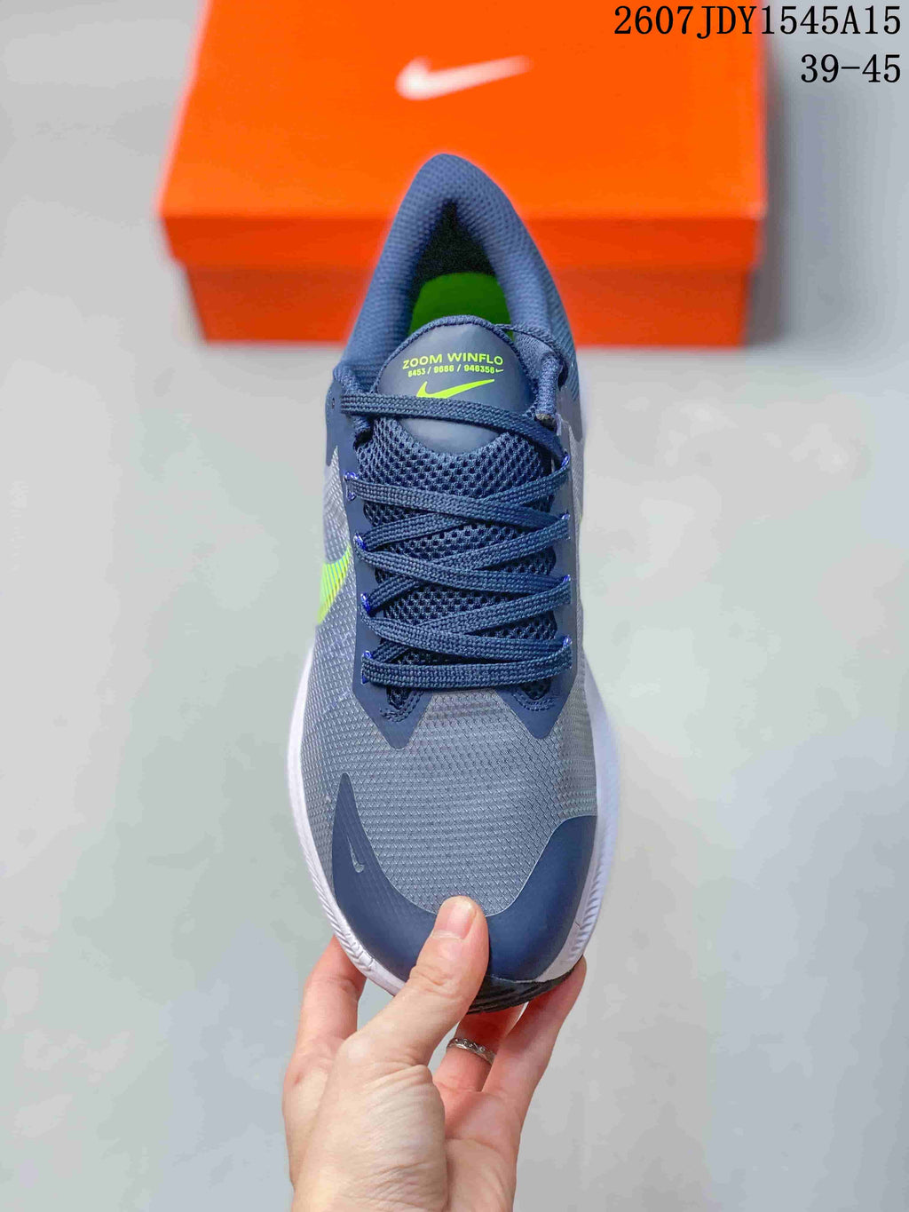 Top view of a Nike Zoom Winflo 8 shoe showing the navy laces, textured gray upper, navy toe panel, and lime green interior.