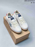 Pair of white Golden Goose Ball Star sneakers displayed on a shoebox, showing the star detail, red heel accents, and the visible 36–45 size range.