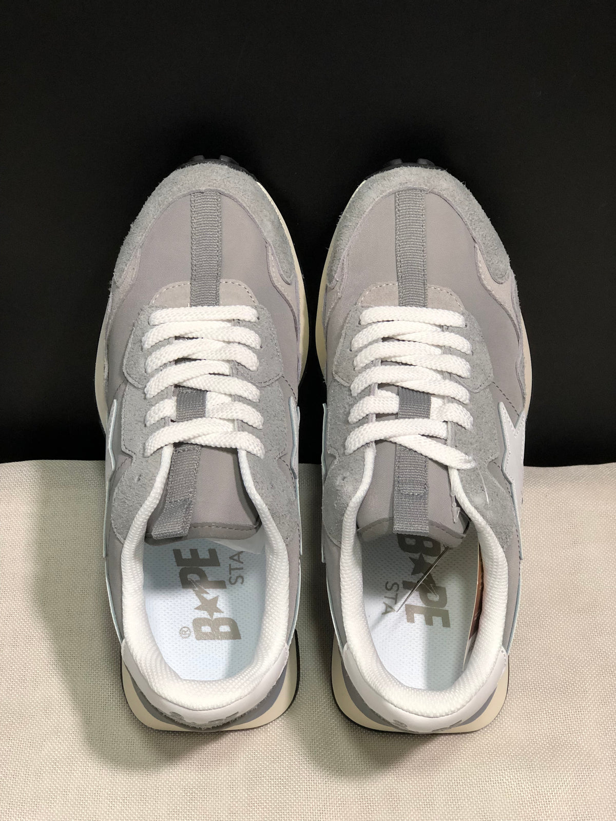 Top view showing the grey layered uppers, white laces, padded collars, and BAPE STA insoles.