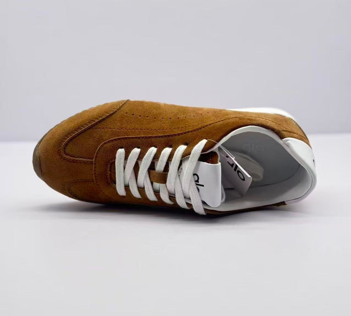 Top-down side view highlighting the lace construction, tongue labels, interior lining, and brown upper.