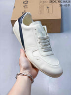 Close-up of a white low-top sneaker with white laces and a navy heel strip.