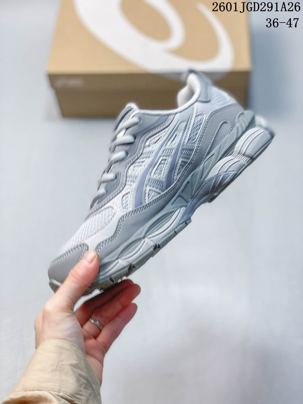 Side profile of the gray sneaker showing layered panels, mesh sections, and the textured outsole.