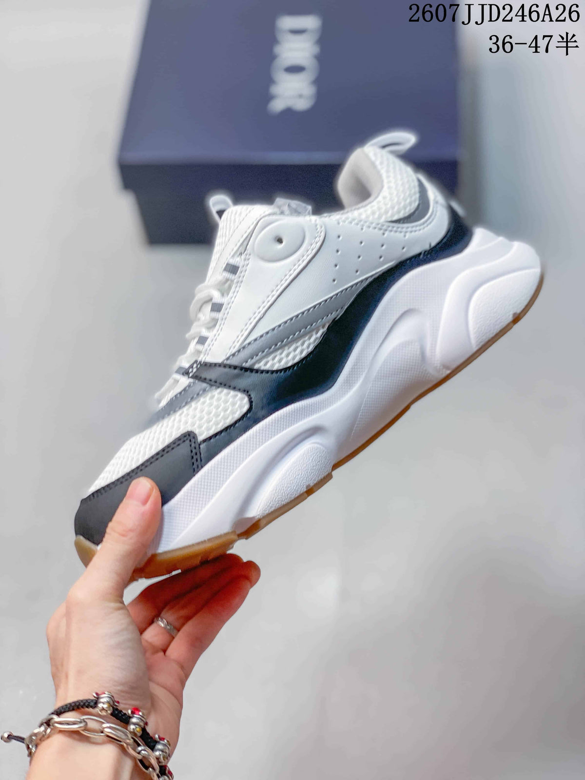 Side view of the white, black, and gray low-top sneaker showing its layered panels and chunky sole.
