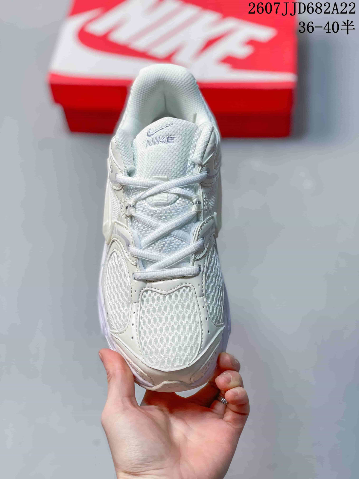 Top view of the white Nike sneaker showing the mesh toe area, lace-up closure, tongue branding, and structured overlays.