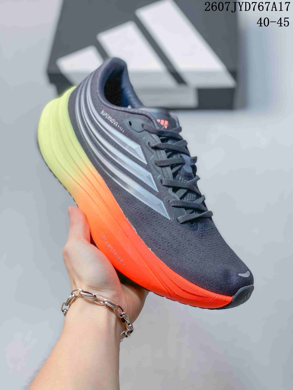 Angled side view of an Adidas Supernova Rise sneaker showing the dark gray upper, silver side stripes, orange sole edge, and lime-green heel; image text shows size range 40–45.