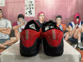 Rear view of red and black low-top basketball shoes with speckled black heels.
