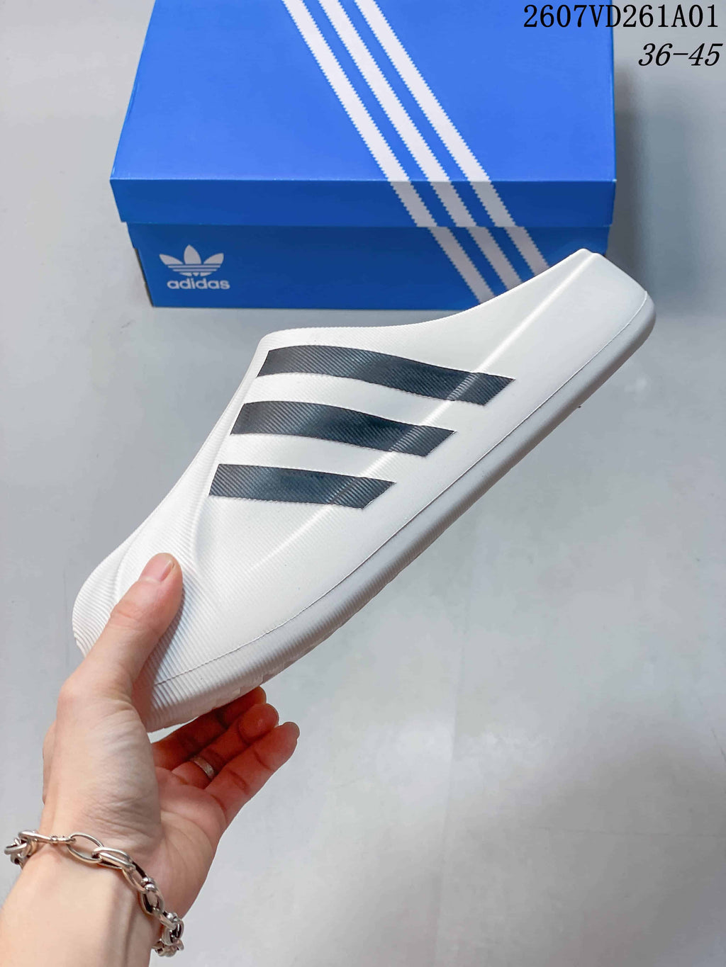 Side view of the white mule slide with three black stripes