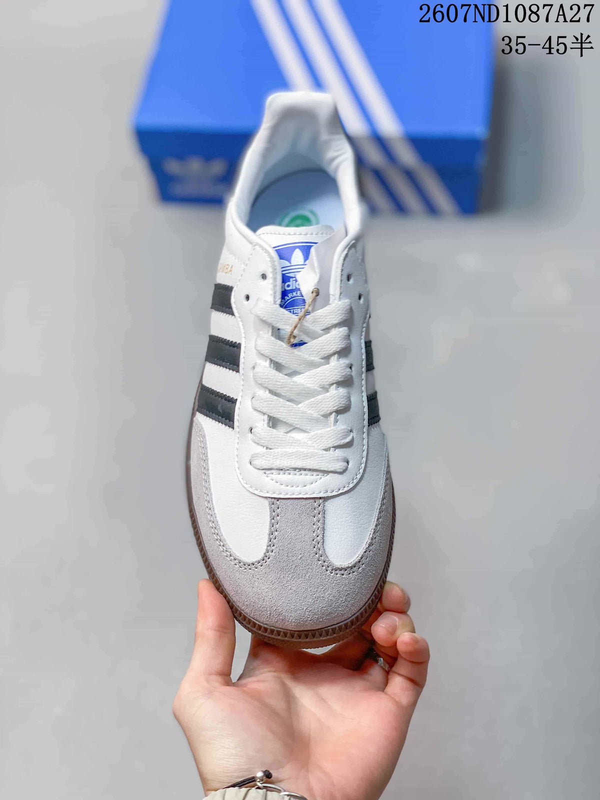 Top view showing white laces, gray toe panels, black stripes and blue adidas tongue branding.