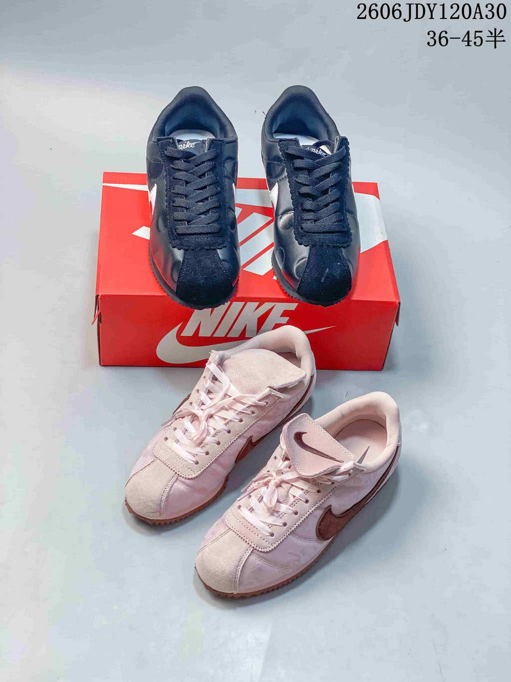 Black and pale pink pairs of low-top sneakers displayed together around a red shoe box.