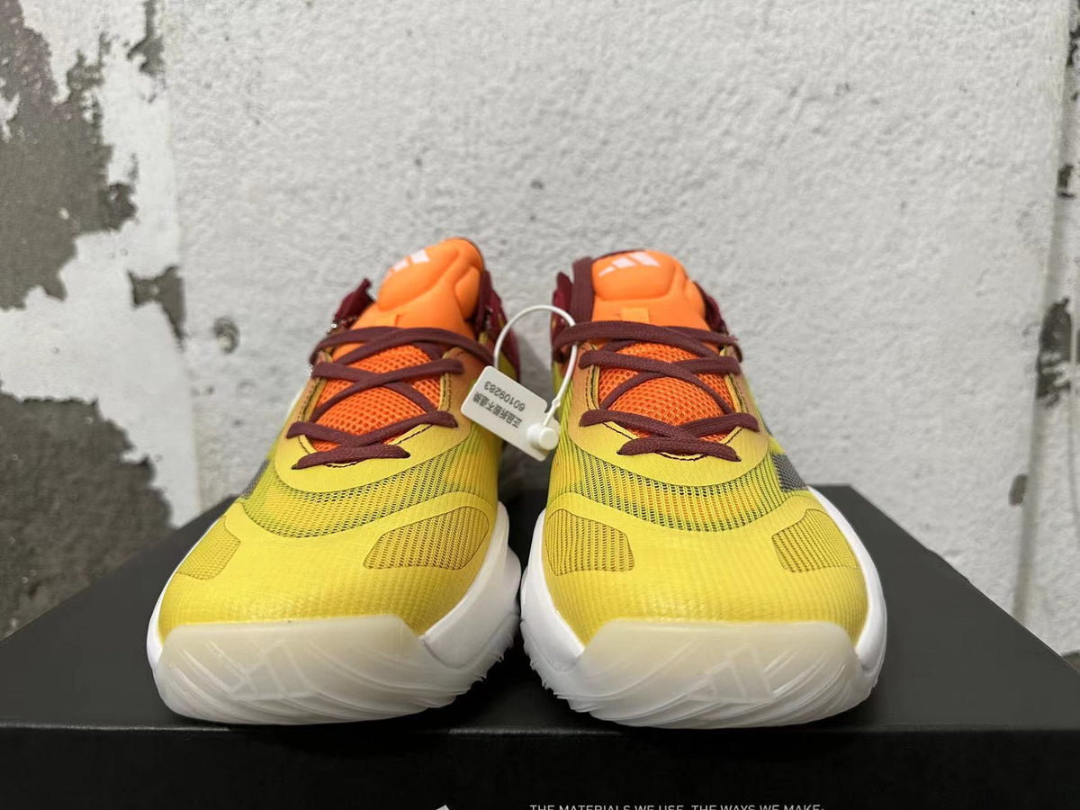 Front view of yellow and orange adidas Adizero sneakers with burgundy laces.