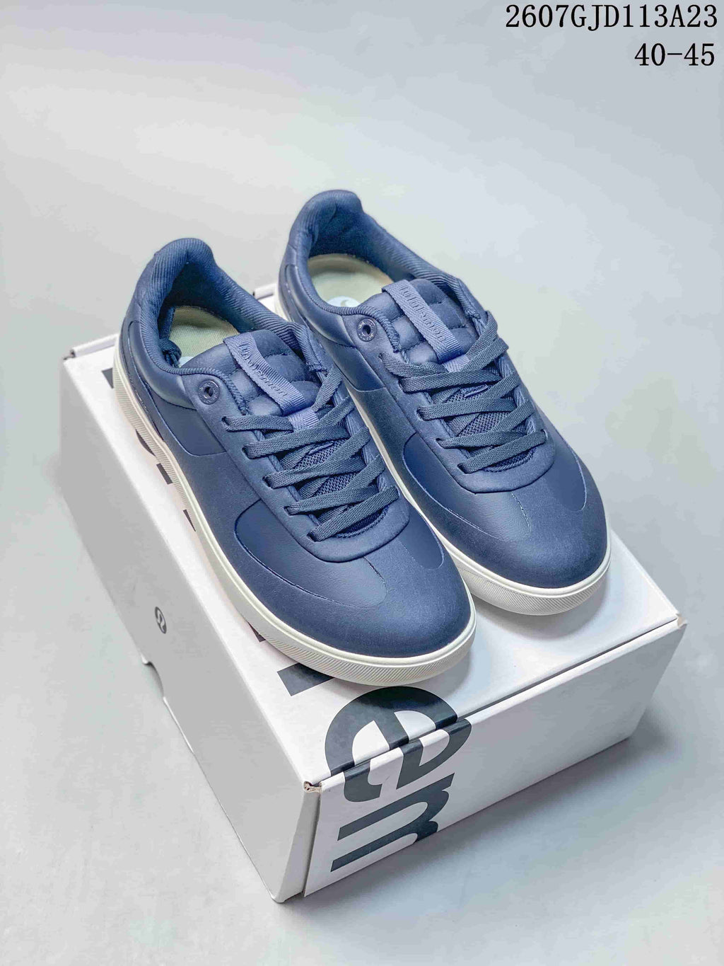 Pair of navy lululemon Cityverse low-top sneakers with matching laces and white outsoles displayed on a shoebox; image text shows style code 2607GJD113A23 and size range 40–45.
