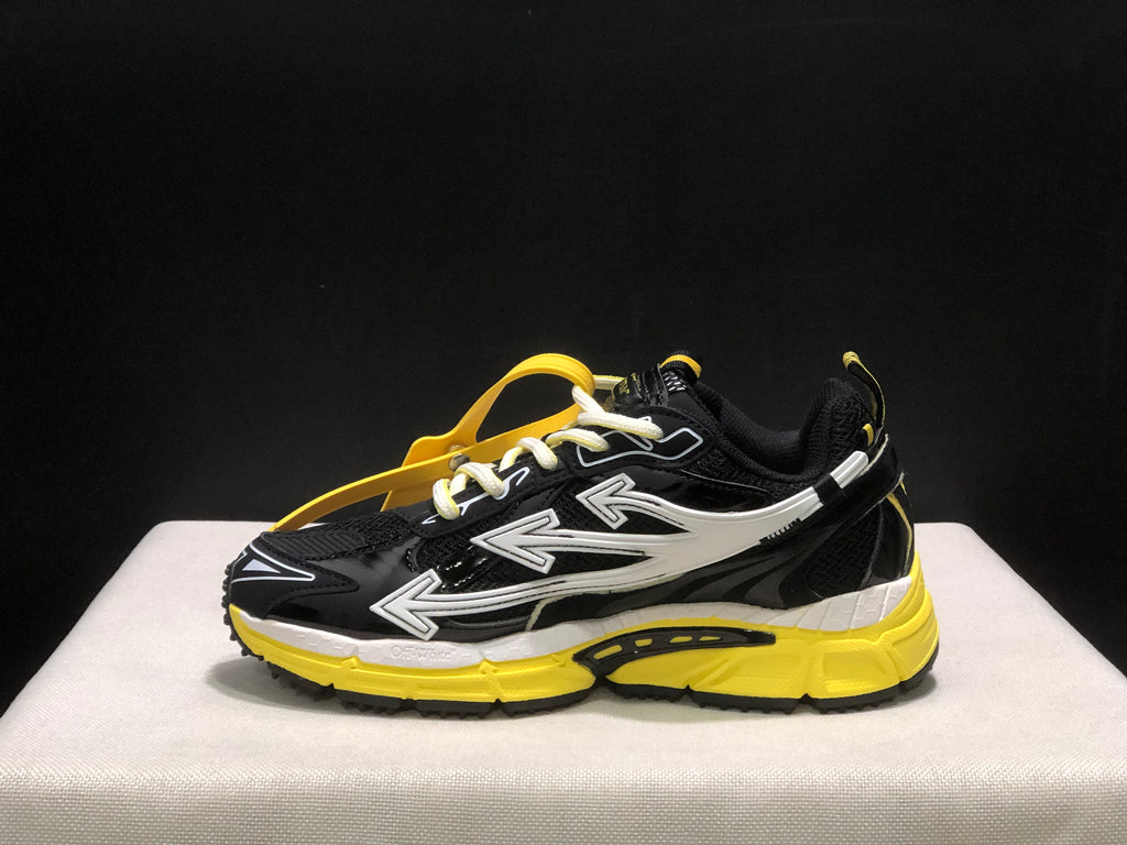 Opposite side profile showing the black upper, white arrow graphics, yellow sole, and attached hangtag.
