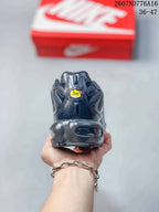 Rear view of a black Nike Air Max Plus sneaker showing the heel structure, rear branding details, and visible cushioning element.