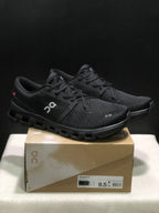 Black On Cloud X4 shoes displayed on a Cloud X4 box, with the box label visible.