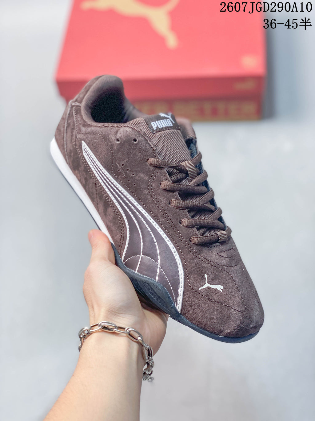 Angled side view of the brown Puma sneaker showing the white formstrip, stitched upper panels and low-profile outsole.