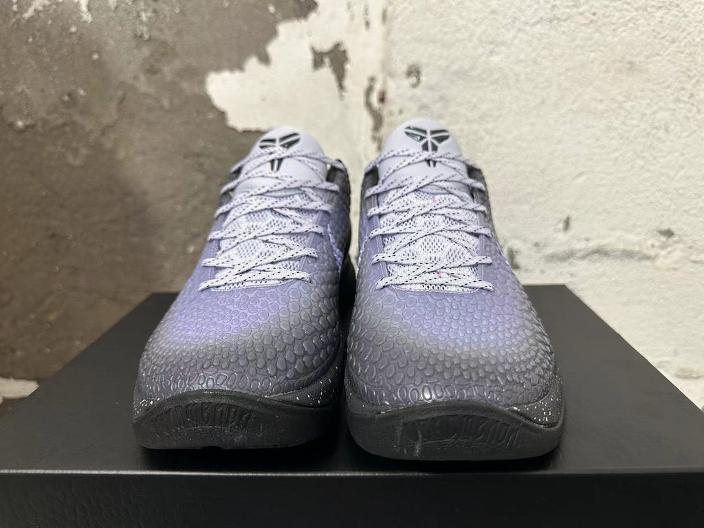 Front view showing the textured dark purple uppers, pale laces, and tongue logos