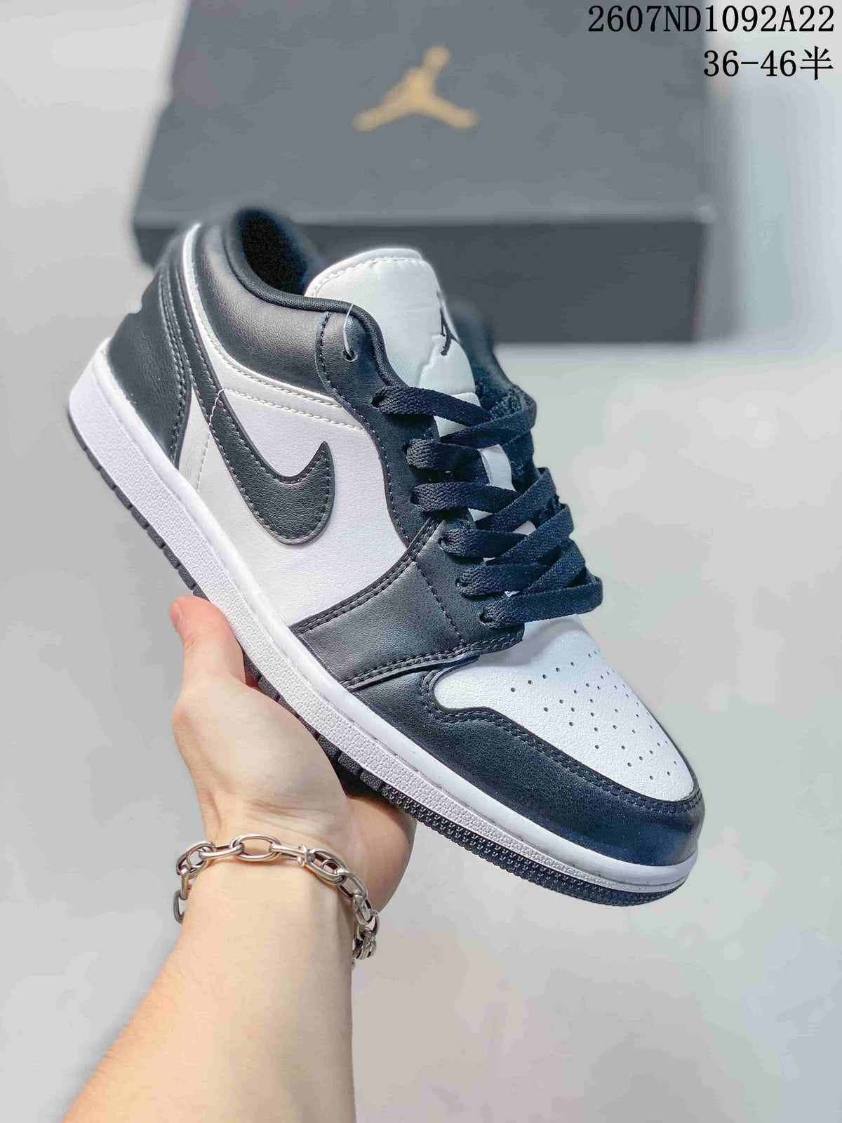 White and black low-top Jordan sneaker with a black Swoosh and dark laces.