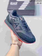Close-up of a dark navy Emporio Armani EA7 sneaker with a contrasting red outsole and dark side branding.